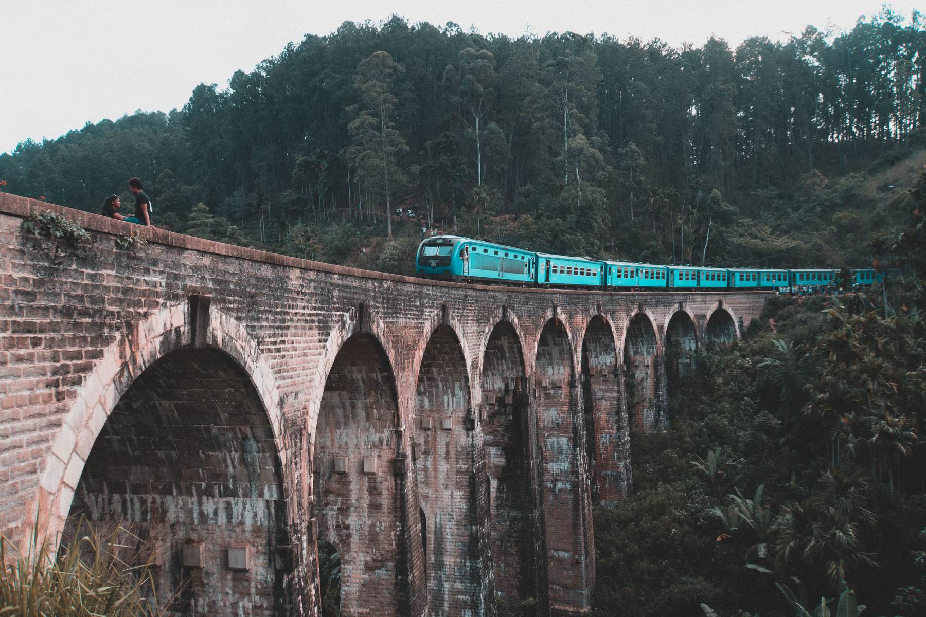 Blue train crossing the Nine Arches Bridge near Ella