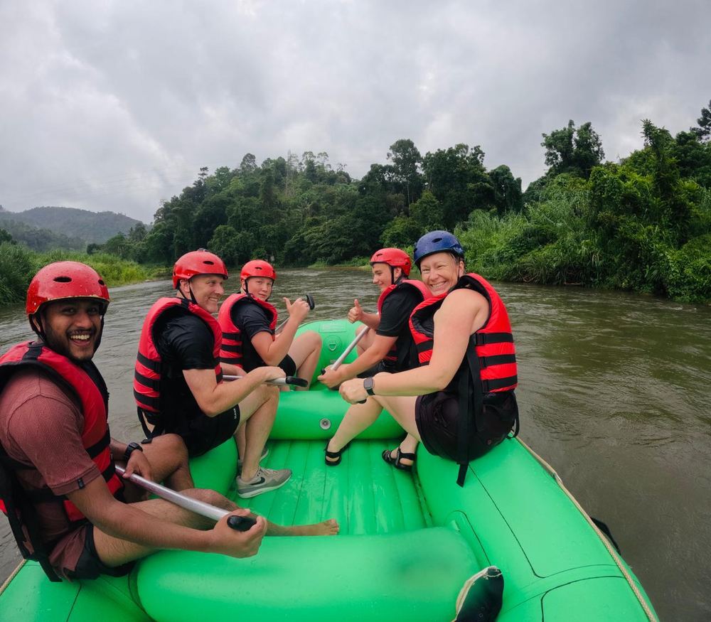 A guide and guests white-water rafting together