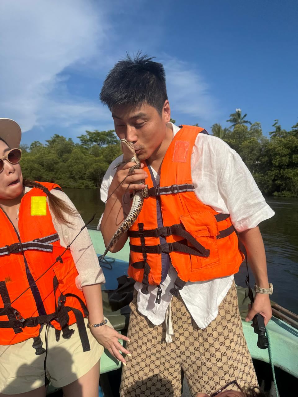 A traveller getting a close look at a snake on a boat safari